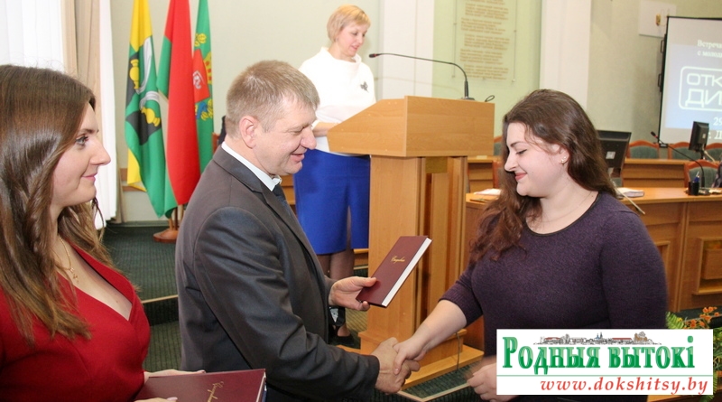 Старшыня райвыканкама Алег Пінчук уручае падарунак маладому ўрачу Докшыцкай ЦРБ Таццяне Ключнікавай.