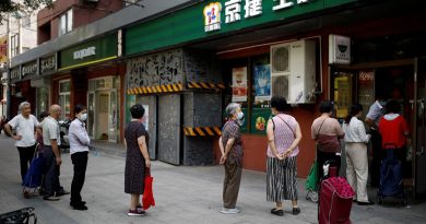 People wearing face masks line up outside a food store following a new outbreak of the coronavirus disease (COVID-19) in Beijing, China, June 19, 2020. REUTERS/Carlos Garcia Rawlins