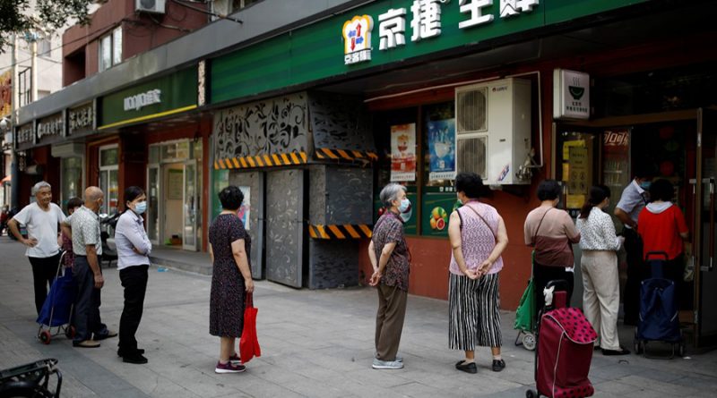 People wearing face masks line up outside a food store following a new outbreak of the coronavirus disease (COVID-19) in Beijing, China, June 19, 2020. REUTERS/Carlos Garcia Rawlins