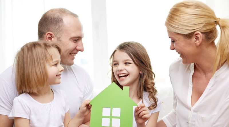 smiling parents and two little girls at new home