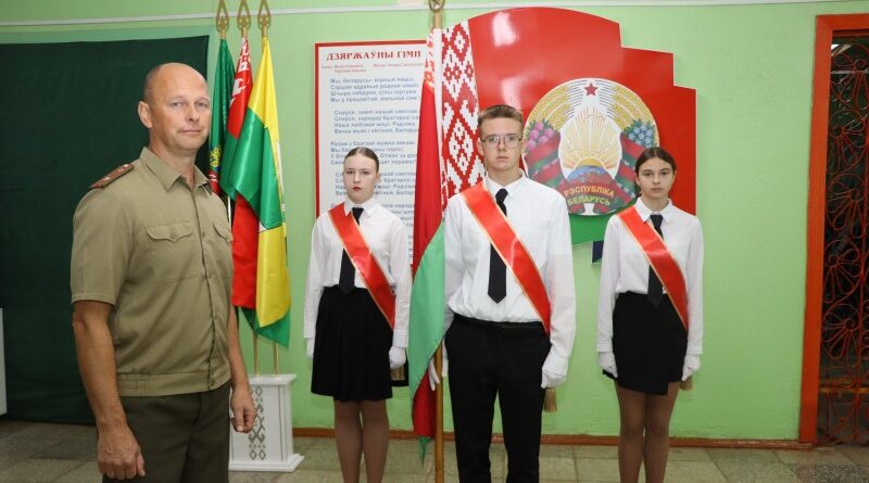 Алег Камінскі са школьнай сцяганоснай групай, якую рыхтуе да ўрачыстых мерапрыемстваў.