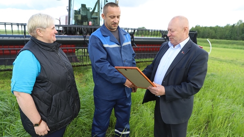 З узнагародай Паўла Рудзько віншуюць Васіль Васюковіч і старшыня прафпярвічкі ААТ “Таргуны” Алена Кукуля.